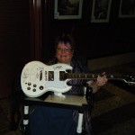 Trish holding guitar autographed by Zoot members